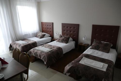 a hotel room with two beds and a table at Belweder in Białystok