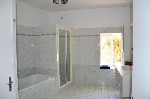 een badkamer met een bad en een wastafel bij La Roche Cantin in Cherveux