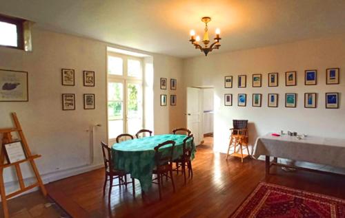 une salle à manger avec une table et des chaises vertes dans l'établissement La Roche Cantin, à Cherveux