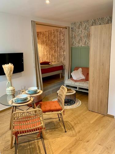 un salon avec une table et des chaises et une chambre dans l'établissement Natural Suite en centre ville avec SPA et jardin, à Dijon