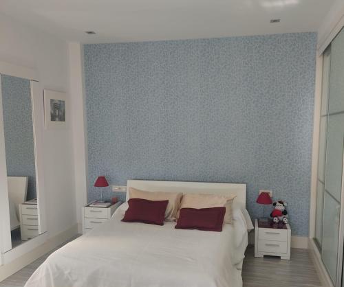 a bedroom with a large white bed with two night stands at Villa 28 de julio Casa Rural con piscina en Granada in Granada