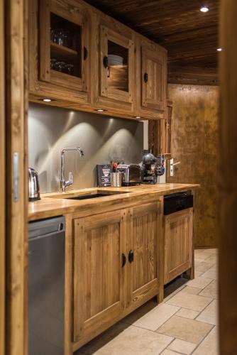 a kitchen with wooden cabinets and a sink at Norberts Place in Lanslevillard