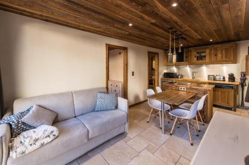 ein Wohnzimmer mit einem Sofa und einem Tisch in der Unterkunft Norberts Place in Lanslevillard