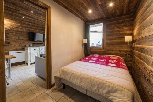 1 dormitorio con 1 cama en una habitación con paredes de madera en Norberts Place, en Lanslevillard