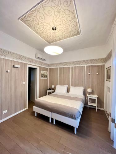 a bedroom with a large bed with a ceiling at Hotel La Pace in San Mauro Torinese