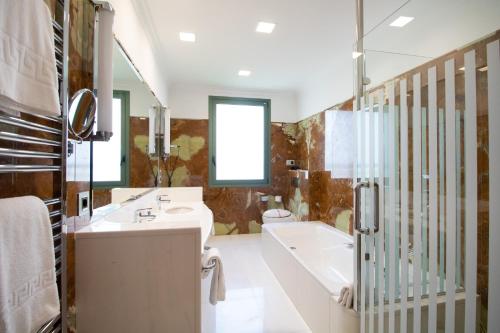 uma casa de banho com 2 lavatórios, uma banheira e um chuveiro em Alda Mirador del Moncayo em Olvega