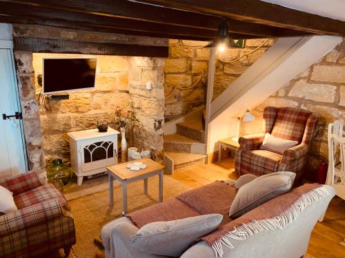 a living room with a couch and a fireplace at Cosy 400yr old Cottage, Flowergate, Whitby, Sleeps 6 in Whitby