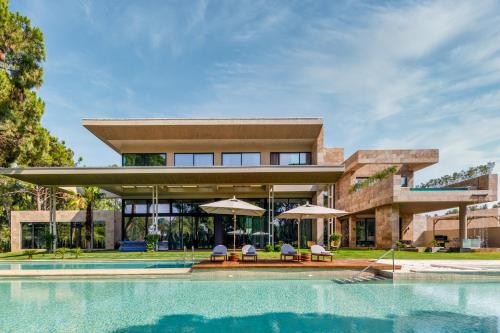 an exterior view of a house with a swimming pool at Kaya Palazzo Golf Resort in Belek