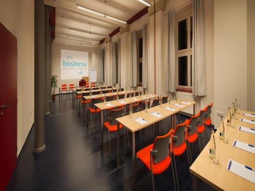 a large room with tables and chairs and a sign at EA Business Hotel Jihlava in Jihlava