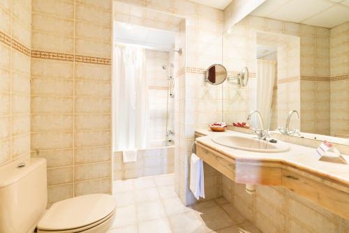 y baño con aseo y lavamanos. en Hotel Guitart Rosa - Adults Only, en Lloret de Mar