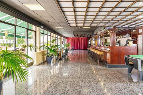 een restaurant met potplanten en een pooltafel bij Hotel Guitart Rosa - Adults Only in Lloret de Mar