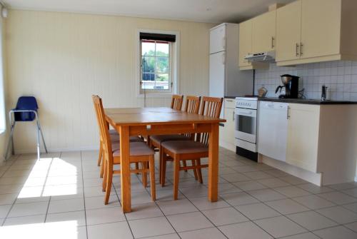 a kitchen with a wooden table and chairs in it at Beverøya Hytteutleie og Camping in Bø