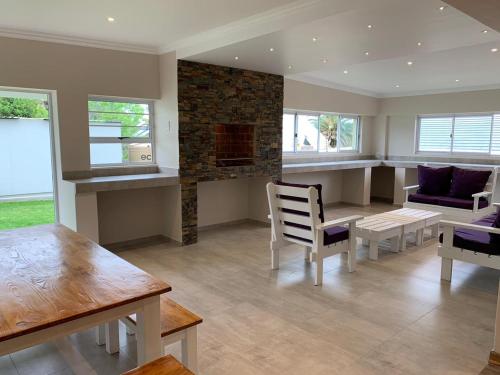 a living room with a fireplace and a table and chairs at TeBeacon Accommodation in East London