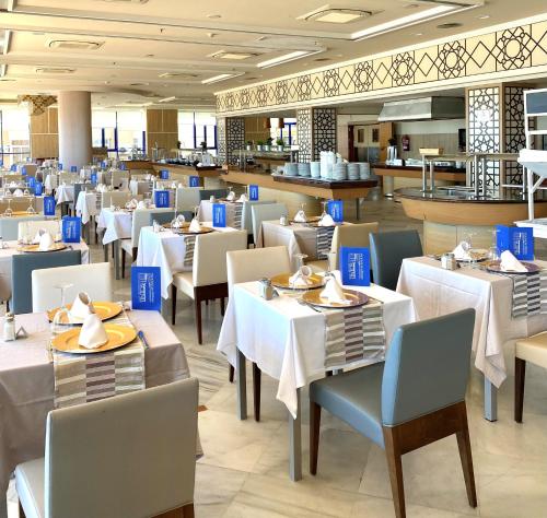 a dining room with white tables and chairs at Hotel Yaramar - Adults Recommended in Fuengirola