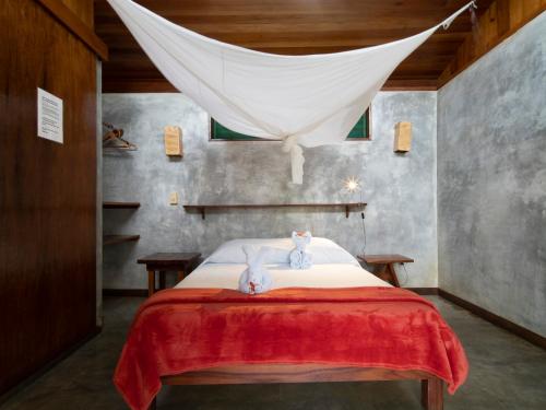 a bedroom with two mice sitting on a bed at Hotel Finca Maresia in Drake