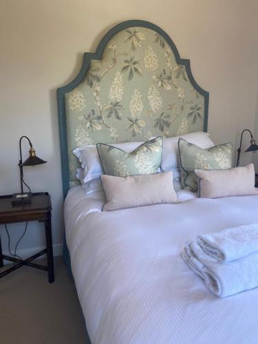 a bedroom with a large bed with a large headboard at The Seagrave Arms in Weston Subedge