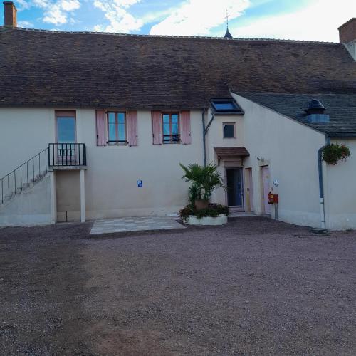 uma grande casa branca com um alpendre e uma entrada em Hôtel du Cerf em La Guerche-sur-lʼAubois