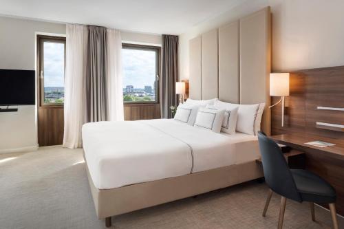 杜塞道夫的住宿－杜塞爾多夫美利亞酒店，酒店客房设有一张大床和一张书桌。