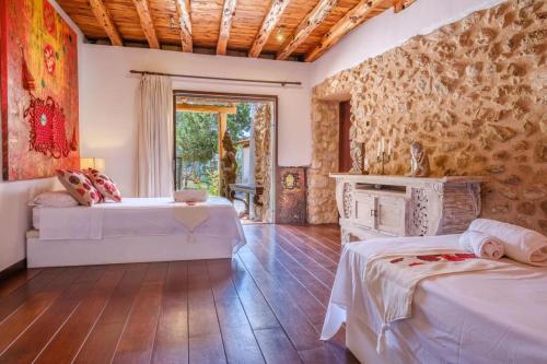 a hotel room with two beds and a fireplace at Can Sabina - San Antonio in Santa Agnès de Corona