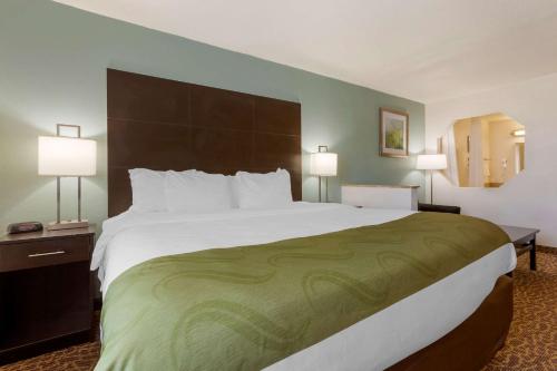 a large bed in a hotel room with two lamps at Quality Inn Alexis Rd in Toledo