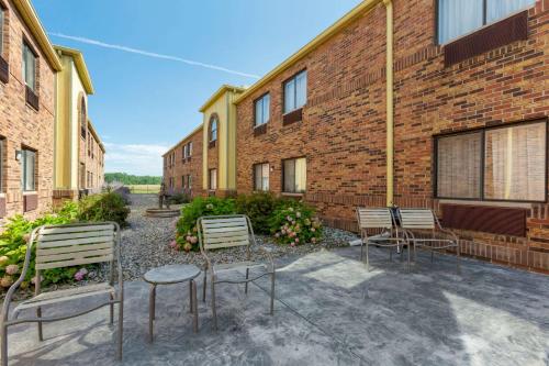 a group of chairs sitting next to a brick building at Quality Inn Alexis Rd in Toledo