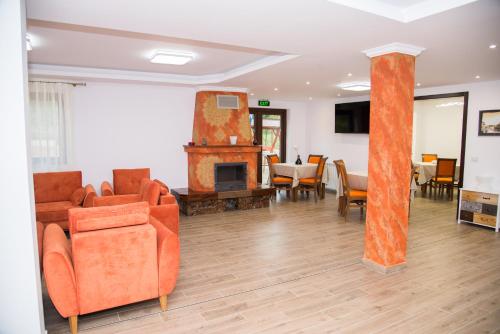 a living room with orange furniture and a fireplace at Poiana Transilvaniei in Viştea de Sus