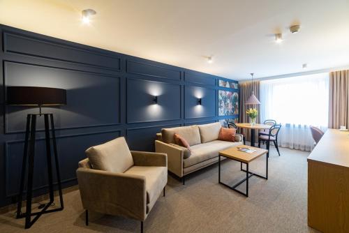 a living room with a couch and chairs and a table at Hotel Jubilat in Zamość