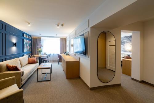 a living room with a couch and a mirror at Hotel Jubilat in Zamość