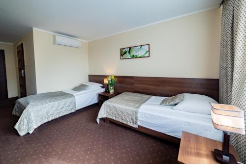 a hotel room with two beds and a table at Hotel Jubilat in Zamość