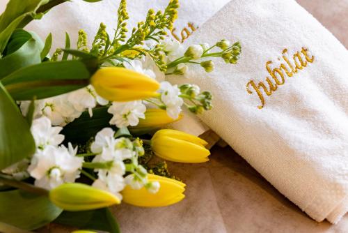 a bouquet of yellow flowers and a napkin with the word autism at Hotel Jubilat in Zamość