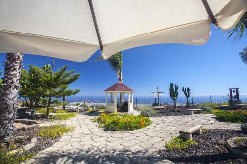 une terrasse avec un parasol et un kiosque dans l'établissement Eco Finca Vista Bonita, à San Miguel de Abona