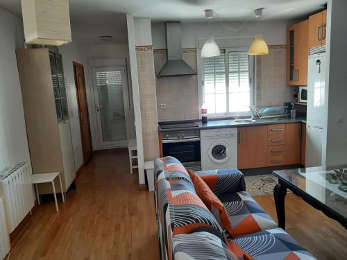 ein Wohnzimmer mit Couch und Küche in der Unterkunft El Mirador de la Sierra in Benaocaz