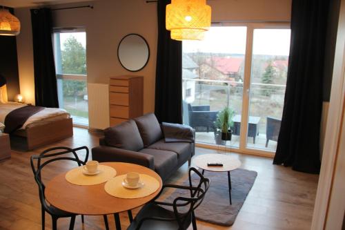 a living room with a couch and a table and chairs at Aparthotel - Buk in Buk