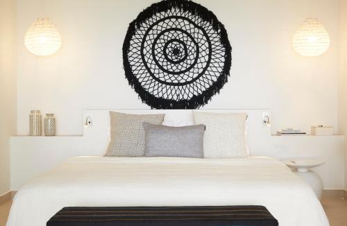 a bedroom with a bed with a black and white mandala on the wall at Eagles Villas - Small Luxury Hotels of The World in Ouranoupoli