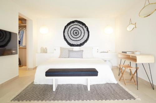 a white bedroom with a white bed and a desk at Eagles Villas - Small Luxury Hotels of The World in Ouranoupoli