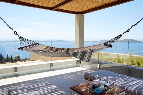 a hammock on a patio with a view of the ocean at Eagles Villas - Small Luxury Hotels of The World in Ouranoupoli