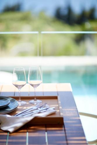 two wine glasses sitting on top of a table at Eagles Villas - Small Luxury Hotels of The World in Ouranoupoli