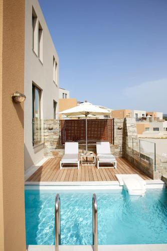 a swimming pool with two chairs and an umbrella at Eagles Villas - Small Luxury Hotels of The World in Ouranoupoli