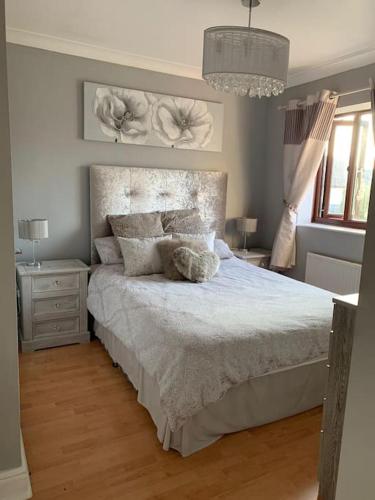 a bedroom with a large bed with white sheets and pillows at Spacious 2 BR home close to town & coast + parking in Uzmaston
