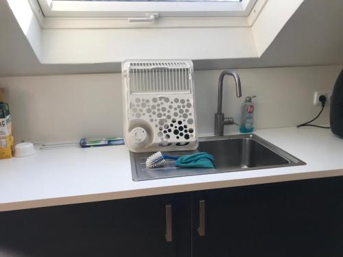 a kitchen sink with a dish drying rack next to it at FeWoWe Ferienwohnung Wenden in Wenden