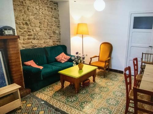 un salon avec un canapé vert et une table dans l'établissement Rosella - maison de charme au cœur du village, à Argelès-sur-Mer