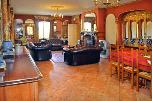 a living room with leather furniture and a fireplace at Beautiful Château with Private Pool near Cahors in Cambayrac