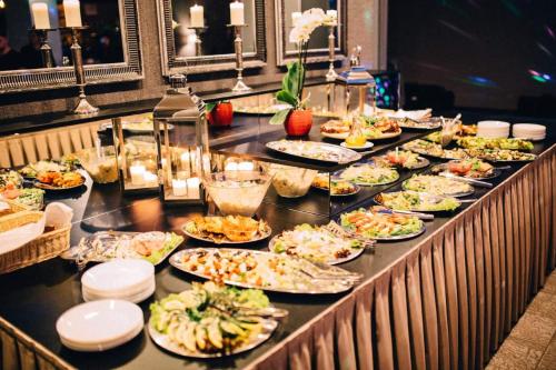 a buffet with many plates of food on a table at Hotel Jubilat in Zamość
