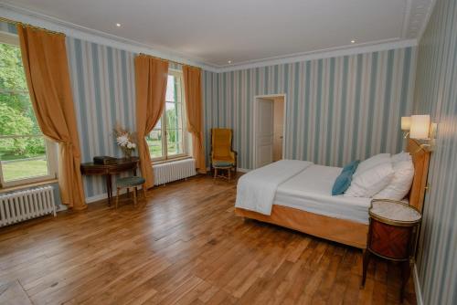 a bedroom with a bed and a table and chairs at Domaine du Chateau Vert in Hondainville