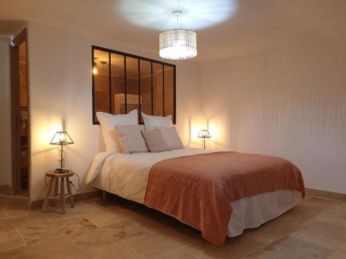 una camera con un grande letto con due lampade di MAS DU RECATI a Caderousse