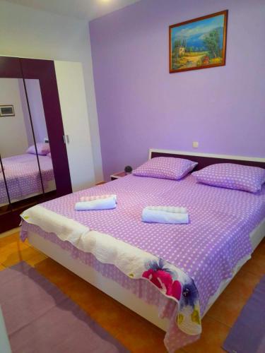 a purple bedroom with a bed with a teddy bear on it at House Fantazija in Rab