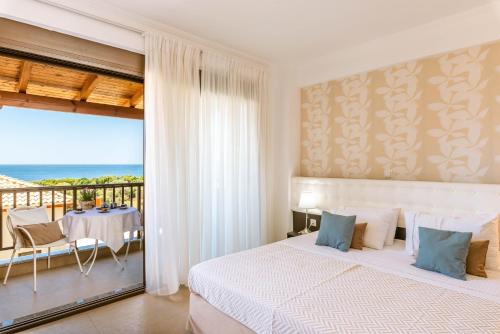 a bedroom with a bed and a balcony with the ocean at 3Aktes Suites & Studios in Syvota