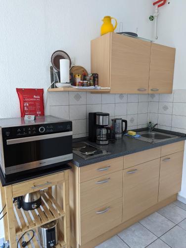 uma cozinha com um lavatório e um fogão forno superior em Gemütliche Ferienwohnung in der Lüneburger Heide em Sprakensehl