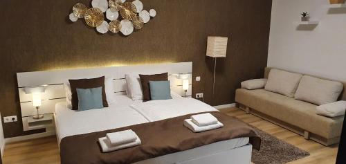 a bedroom with a large bed and a couch at Sunset Wellness Apartman Zalakaros in Zalakaros