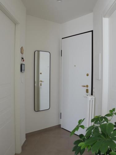 a mirror in a white room with a plant at Residenze Aimone in Vasto